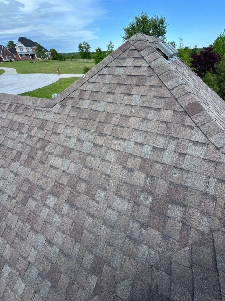 Hail impacts marked on weathered wood shingles during a storm damage inspection in Kinkade Village, Ozark, MO