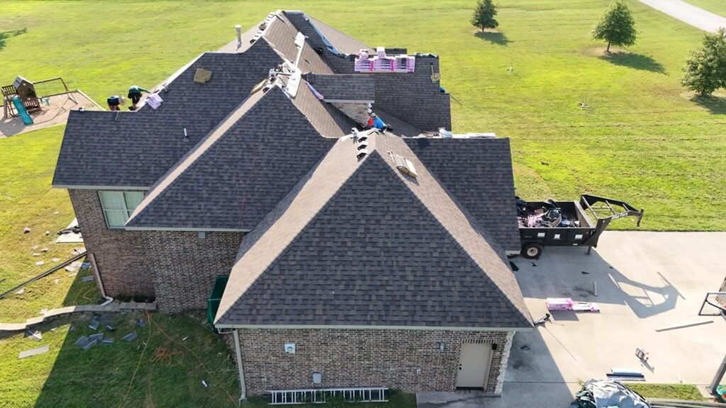 Aerial view of new Teak architectural shingles being installed on an Ozark, MO home