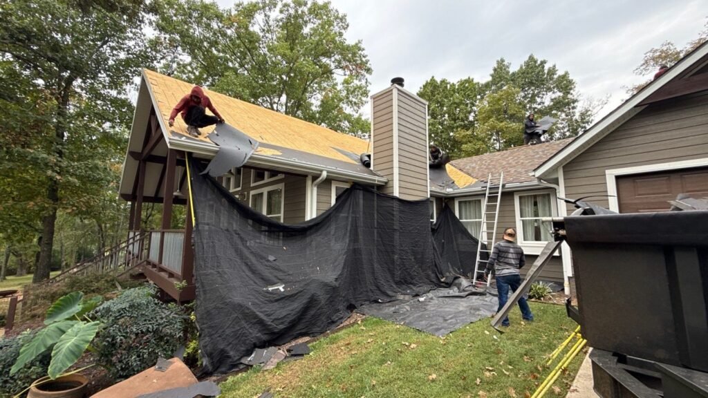Roof tear-off with debris netting protecting gutters, gutter guards and landscaping on a steep home near Branson West, MO